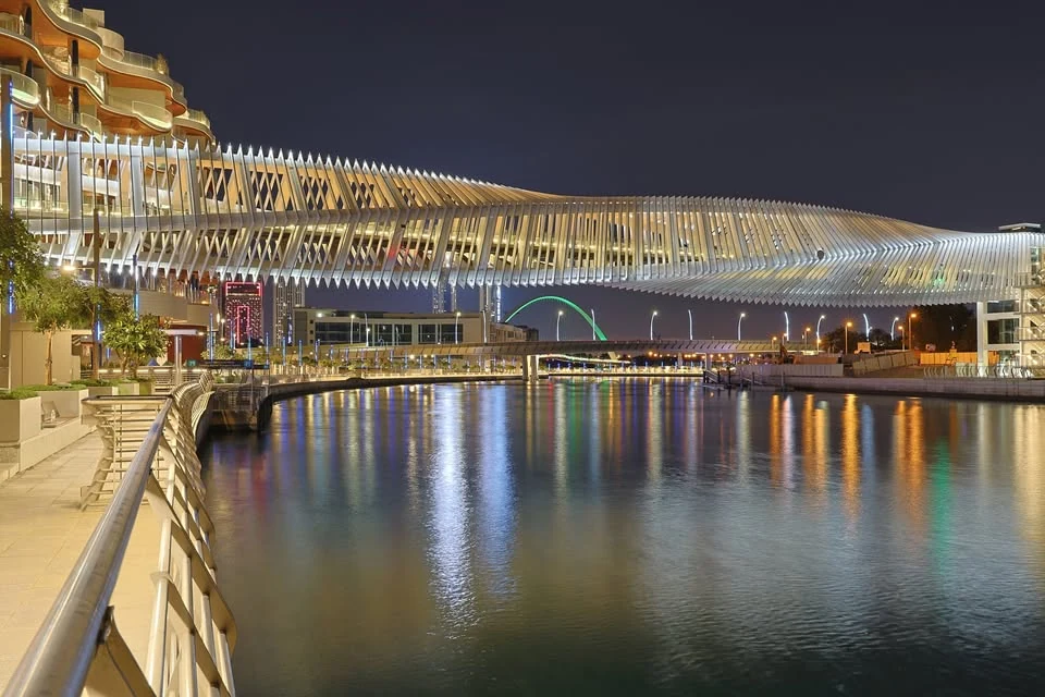 Fotografía nocturna de arquitectura y puente reflejado en agua
